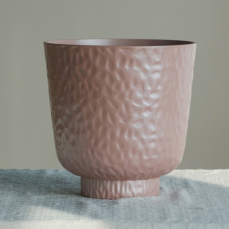 Dusty pink textured planter pot with tray resting on a tabletop