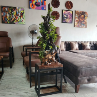 Handcrafted driftwood planter with artificial plant displayed on a wooden side table in a modern Lagos living room