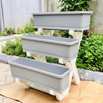 3-tier multi layer planter with grey rectangular troughs on a white frame setup outdoors